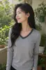 Suministrado directamente por la fábrica de ropa de origen, top versátil de retazos para mujer de talla grande de otoño con manga larga y cuello en V, disponible para pedidos personalizados con sus propios diseños o muestras.