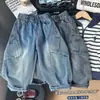 Roupas novas para crianças 2026, coleção de outono para meninos, calças estilo workwear com bolsos grandes, jeans do papai, jeans de perna curva, atacado