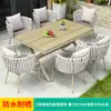 Conjunto de mesa e cadeiras de vime para varanda em estilo nórdico, com estrutura em plástico e madeira, cadeiras simples para uso doméstico.