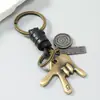 Llavero vintage minimalista de aleación con gesto y cordón de cuero, colgante de metal tejido, accesorio de regalo personalizado para parejas estilo europeo y americano