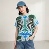 Camiseta Feminina Miyake Plissada Manga Curta Base Menta Clara Estampa Simétrica de Macacos da Floresta Tropical Folhas Gola Redonda Textura Solta