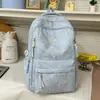 Mochila estilo universitário azul gelo claro com padrão escuro em formato de coração, com alças de ombro largas ajustáveis para alunos do ensino fundamental II e médio