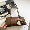 Bolso retro para debajo del brazo para mujer, bolso de hombro de cuero suave de nicho, bolso pequeño cilíndrico con dije de oso, bolso de mano multicolor para el día a día