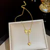 Versión coreana del nuevo y versátil exquisito collar de acero de titanio con lazo para mujer, lujo ligero, alto sentido, borla, amor, cadena para clavícula, venta al por mayor