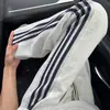 Pantalones deportivos casuales grises claros de tres rayas para hombre, pantalones rectos a rayas de uso rudo para primavera y otoño, pantalones largos acampanados deportivos estilo americano
