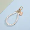 Llavero de correa de teléfono de perlas estilo Chanel para niñas con lazo en forma de corazón, flor y colgante de metal, accesorio para bolso