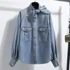 Foto Real de una Chaqueta Camisa de Mezclilla Holgada para Mujer con Cuello Alto de Atar, Bolsillos de Trabajo, Botones Dorados Vintage y Mangas de Linterna