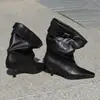 Botas negras de moda y con estilo hasta la mitad de la pantorrilla para mujer, combinadas con una falda, son geniales y chic, con tacones altos y punta fina
