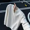 Camiseta negra de manga larga con cuello en V para hombre, colección de otoño, con un diseño texturizado y calado, perfecta como capa base o prenda interior.