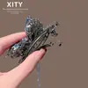 Pinza para el pelo de cristal azul con mariposa de nuevo estilo coreano y japonés, de lujo ligero, para mujer, pinza de resorte para flequillo lateral con borla, accesorio para el pelo versátil y elegante