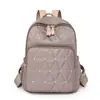 Comercio exterior al por mayor 2025 nuevo bolso de hombro casual para mujer de nailon moda remache almacenamiento exterior mochila de viaje tendencia