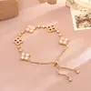 Pulsera de trébol de cuatro hojas rojo con microincrustaciones de circonita en cobre, tipo cordón ajustable, estilo socialité de temperamento, joyería de mano delicada y elegante, venta al por mayor