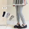 Venta al por mayor transfronteriza leggings nuevos para niñas primavera y otoño 2026 para usar como prenda exterior, pantalones de algodón a rayas verticales para niños con múltiples lazos, longitud recortada