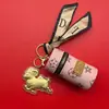 Bolsa cilíndrica de cuero popular Shuibei de oro 999 con colgante de cordero de la fortuna, regalo promocional de alta gama infundido en oro para el Año Nuevo