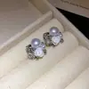 Aretes de flor de resina perlada incrustados con diamantes estilo francés, que exudan un ambiente lujoso y elegante, con un diseño moderno y único