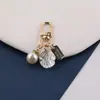 Nuevo hebilla de puerta creativa con corazón hueco de aleación de perla, llavero, funda de auriculares y charm para bolso DIY, joyería