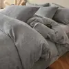 Juego de ropa de cama de cuatro piezas de terciopelo de leche engrosado y bordado para otoño e invierno, que incluye sábanas cálidas, funda de edredón y sábana bajera, diseñado para el dormitorio principal con una estética simple pero elegante.