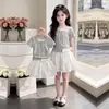 Moda Niña 2026 Top Delgado de Manga Corta de Moda Verano Dulce Princesa Moño Encaje Falda Conjunto de Dos Piezas