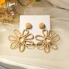 Pendientes de estilo veraniego transfronterizo europeo y americano para mujer, con flores huecas de hierba Rafi tejidas a mano y coloridos distintivos.