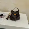 Bolso pequeño de alta gama estilo francés para mujer 2026 nuevo moda otoño e invierno patrón de diamantes bolso cubo diseño de nicho bolso cruzado