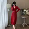 Elegante vestido de punto rojo para mujer en invierno, con un diseño que ciñe la cintura, adecuado para combinar con un abrigo o como un vestido largo de capa base