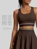 Camiseta deportiva de tirantes cruzados de malla color durazno con parches, franjas de color contrastante, copas fijas en el busto y sujetador de yoga a prueba de impactos.