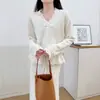 Tejido de punto hueco, suave y elegante, estilo coreano para mujer, nueva colección otoño e invierno, conjunto de dos piezas de suéter con lazo en la cintura y falda