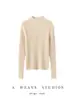 Nova coleção outono/inverno 2026: Camada base feminina de malha canelada, com corte justo que valoriza a silhueta, gola semi-alta e acabamento franzido, feita de 100% cashmere puro