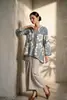 Kimono con estampado floral del sudeste asiático, con mangas holgadas de tres cuartos, usado como capa exterior sobre una camisa de murciélago. Venta al por mayor desde la fábrica de origen