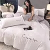 Venta al por mayor del fabricante Juego de cuatro piezas de color sólido de lujo ligero Rojo brillante Sábanas de cama bordadas para bodas Funda de edredón Algodón lavado Ropa de cama cepillada