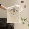 Chegada Nova Verão 2026 Camiseta com Estampa de Letras Gola Redonda Ombro Normal Manga Curta para Mulheres Emagrecedora Casual Versátil Top Chique