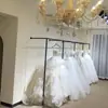 Suporte de Exibição para Loja de Vestidos de Noiva em Ferro Forjado Arara de Roupa Montada na Parede para Loja de Roupas Estúdio Fotográfico Prateleiras Especiais para Trajes Formais e Trajes Xiuhe Feito Sob Medida