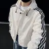 Chaqueta cortavientos casual holgada estilo coreano transfronteriza, nueva colección primavera/otoño, diseño con capucha de tres rayas para hombre, versátil y estiliza, moderno