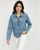 Top jeans feminino de manga longa com gola e zíper parcial, apresentando acabamento lavado e desgastado, corte solto e barra arredondada.. Direto do fabricante