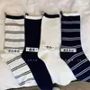 Meias femininas de outono e inverno estilo coreano com listras e color blocking, azul marinho com etiqueta de tecido no calcanhar, meias de cano médio versáteis e da moda