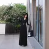 Vestido elegante de gola V com mangas compridas, estilo Maillard, com cintura marcada e saia longa que valoriza a silhueta, acompanhado de cinto combinando.