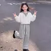 Conjunto versátil de dos piezas para niñas 2026 con un top con capucha de bloques de color combinado con pantalones sencillos, casuales y de color liso