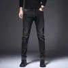Jeans masculinos slim-fit pretos e cinzas de alta qualidade para o Outono/Inverno 2026, calças compridas casuais trendy e elásticas com forro de fleece