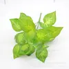 Venta al por mayor de fábrica planta verde de simulación 7 hojas de perilla de corazón rojo planta artificial hojas de vestido de novia flor adornos para fotografía