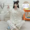 Pijama de cardigã com acabamento em renda para mulheres, apresentando uma estampa discreta de flor de cerejeira, com bojos embutidos, mangas compridas e calças compridas, adequado para usar tanto em ambientes internos quanto externos como roupa de casa.