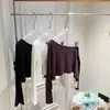 Camisa corta asimétrica de hombros descubiertos, ligera, texturizada, de corte holgado, en mezcla de lyocell y lino, en morado, blanco y negro, con mangas largas
