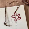 Collar de amor con flores huecas rojas para mujer, otoño e invierno 2024, nuevo estilo coreano, cadena de suéter de moda de alta gama.