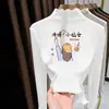 Camiseta Manga Longa Gola Alta Meia para Meninas Coleção Outono/Inverno 2026 Tamanho Médio/Grande Camisa Térmica Base Ajustada com Acabamento em Babado