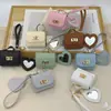 Mini bolsa de presente simples pode guardar fones de ouvido e chaveiros, bolsa de fone de ouvido de cor sólida, pingente de couro, bolsa quadrada criativa, bolsa longa