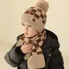 Novo estilo conjunto de chapéu e cachecol de malha xadrez com rosto sorridente em jacquard para crianças, chapéu de malha espesso de inverno quente com pompom
