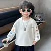 Camiseta deportiva blanca de moda con cuello redondo y manga larga para niños de primaria con estampado de dibujos animados, corte holgado, top estiloso para niños pequeños