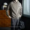 Moletom cardigã de tricô com zíper e capuz masculino com costura em cor contrastante e mangas raglan, incorporando um estilo relaxado, business-casual com um toque de elegância old-money