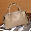 Bolsa de mão em couro genuíno, bolsa estilo bowling de nicho para mulheres, bolsa Boston almofadada moderna e versátil, bolsa transversal de design casual