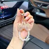 Llavero de lazo de moda con diamantes completos y cadena de perlas, un colgante lindo y brillante para bolsos, cadenas de teléfono y accesorios