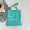 Bolsa de Lona com Estampa de Letras Nova Primavera Grande Capacidade Bolsa de Ombro Feminina Simples Fresca Versátil
